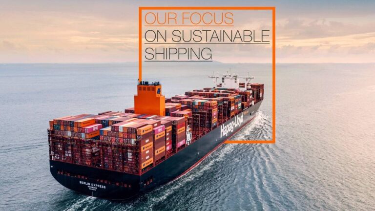 Hapag-Lloyd publishes 2023 sustainability report An aerial shot of a freight ship on the sea, with the words "Our focus on sustainable shipping" on the horizon.