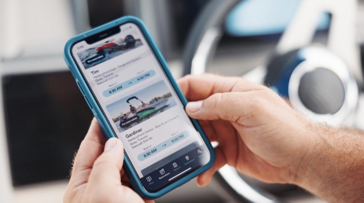 Two hands hold an iPhone, which displays Yamaha's software.