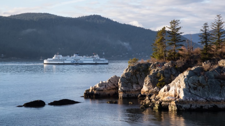 BC Ferries passing by Whytecliff Park in British Columbia, Canada during a vibrant sunset.